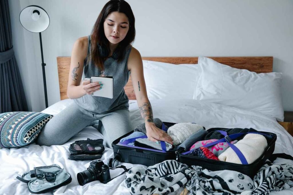 woman packing essential items to bring to Summerfest: water bottle, sunscreen, hat, comfortable shoes, camera, cash, portable charger.